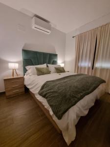 a bedroom with a large bed and a window at Apartamentos La Vera de Gredos in Villanueva de la Vera