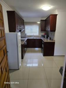 a kitchen with wooden cabinets and a white refrigerator at Durban Overport Halaal Accomodation 5S in Durban +12 photos