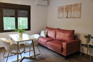 a living room with a red couch and a table at Apartamentos La Vera de Gredos in Villanueva de la Vera