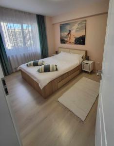 a bedroom with a large bed and a large window at Pink Galaxy in Baciu