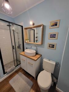 ein Badezimmer mit einem WC, einem Waschbecken und einem Spiegel in der Unterkunft Pink Galaxy in Baciu