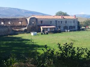 una vecchia casa in un campo vicino a un edificio di Algarabiastaying 3 granja San Julián a Medina de Pomar