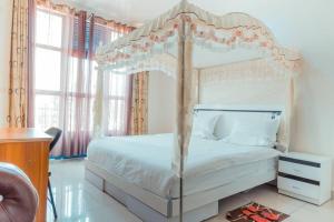 ein Schlafzimmer mit einem weißen Bett mit Baldachin in der Unterkunft Western Mountain Hotel in Rubavu