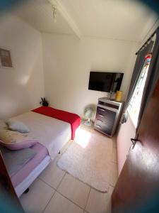 - une chambre avec un lit et une télévision à écran plat dans l'établissement Casa Temporada Espaço Sara Piscina Aquecimento Solar, à São Lourenço