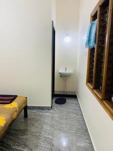 a bathroom with a bed and a sink in a room at Honnavar Pauli s Homestay in Honāvar