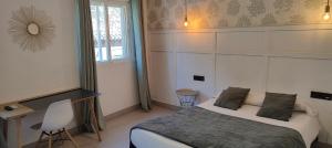 1 dormitorio con cama, escritorio y ventana en Hotel Cedran, en Granada
