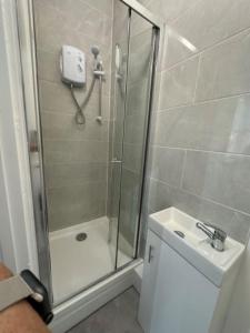 a bathroom with a shower and a toilet and a sink at Central Colwyn Bay Studio Flat 2A in Colwyn Bay +17 photos