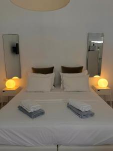 - un lit blanc avec 2 serviettes dans l'établissement CreteSuites - Urban Villa with Pool - 500m to the Beach, à Réthymnon