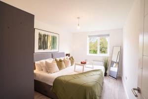 a white bedroom with a bed and a couch at Modern Apt with Free Parking & Park Views in MK in Woolstone