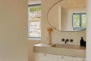 a bathroom with a sink and a mirror at Torretta Le Feritoie - piscina e terrazza vista mare in Fasano