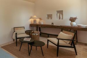 a living room with two chairs and a table at Torretta Le Feritoie - piscina e terrazza vista mare in Fasano