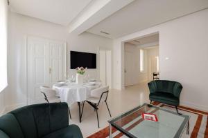 een witte woonkamer met een tafel en stoelen bij Home In The Heart Of Ghirlandina in Modena