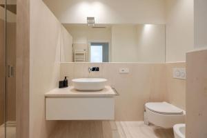 een witte badkamer met een wastafel en een toilet bij Home In The Heart Of Ghirlandina in Modena