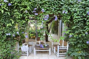 a pergola with a table and chairs and purple flowers at Maison D'Enrì in Gallipoli