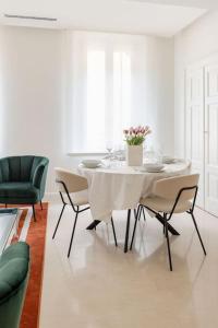 een witte eetkamer met een witte tafel en stoelen bij Home In The Heart Of Ghirlandina in Modena