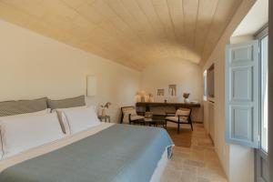a bedroom with a bed and a table in a room at Torretta Le Feritoie - piscina e terrazza vista mare in Fasano