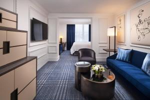 um quarto de hotel com um sofá azul e uma cama em The US Grant, a Luxury Collection Hotel, San Diego em San Diego