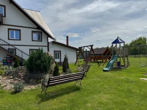 a park with a bench and a playground at Camere de închiriat AnneMaryy in Arbore