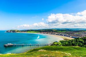 a view of a beach with a pier at Central Colwyn Bay Studio Flat 2A in Colwyn Bay