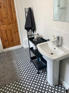 a bathroom with a sink and a mirror and a door at 3 bedroom house in Bedminster near Wapping Wharf in Bristol
