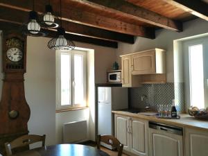 a kitchen with a table and a clock on the wall at Aux gites de Joséphine in Blars