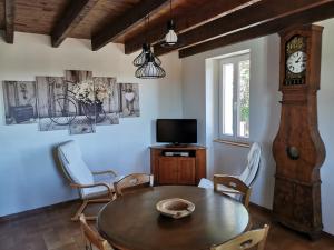 a dining room with a table and a grandfather clock at Aux gites de Joséphine in Blars