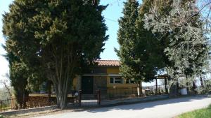 une maison jaune avec une clôture et des arbres dans l'établissement B&B Sei Cipressi, à Impruneta