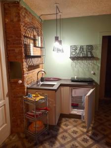 une cuisine avec un évier et un panneau de bar sur le mur dans l'établissement La Porta Verde, à Lucques