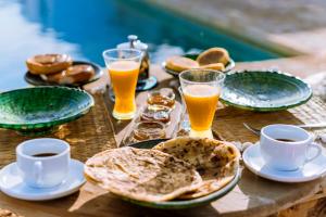 - une table en bois avec des assiettes et des verres de bière dans l'établissement Villa Madame Babouche, chambre Fériel, SdB privative, à Oulad el Madani