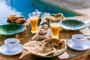 a wooden table topped with plates and glasses of beer at Villa Madame Babouche, chambre Fériel, SdB privative in Oulad el Madani