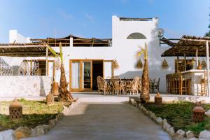a path leading to a white house with a table and chairs at Villa Madame Babouche, chambre Fériel, SdB privative in Oulad el Madani