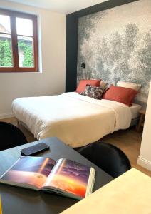a bedroom with two beds and a table with books at L'Adresse Studio Rempart sud - centre historique Eguisheim in Eguisheim