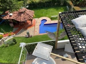 een luchtzicht op een achtertuin met een zwembad en een parasol bij Chalet de Descanso y Tranquilidad in Manizales