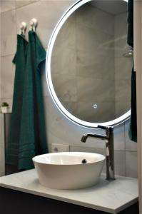 ein Badezimmer mit einem weißen Waschbecken und einem Spiegel in der Unterkunft Mažvydo appartment Klaipėda in Klaipėda