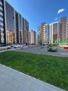 um parque de estacionamento com edifícios altos numa cidade em 1-комнатная комфортная кухня-студия со всеми удобствами em Qostanay