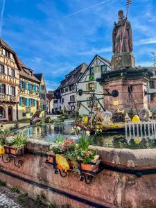 a fountain in a town with a statue at L'Adresse Studio Rempart sud - centre historique Eguisheim in Eguisheim