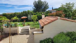 uma casa com um telhado de azulejo e um jardim em MyLuberon-Appartement au pied du Luberon em Lauris