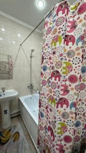 y baño con cortina de ducha y lavamanos. en 1-комнатная комфортная кухня-студия со всеми удобствами en Kostanái