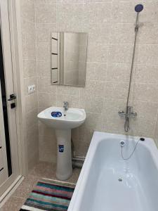a bathroom with a sink and a bath tub at 1-комнатная комфортная кухня-студия со всеми удобствами in Kostanay