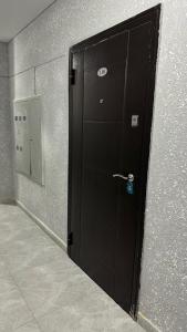 una puerta negra en una habitación con espejo en 1-комнатная комфортная кухня-студия со всеми удобствами en Kostanái