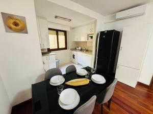 una cucina e una sala da pranzo con tavolo e sedie neri di EL TEMPLE a Saragozza Altre 15 foto