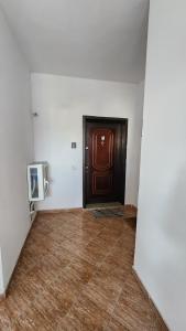um quarto vazio com uma porta e um piso de madeira em Meti Apartment em Durrës
