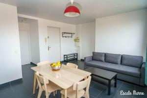 a living room with a table and a couch at Escale-marne fr - 202 - Free Parking - Free Luggage Storage - Metro 8 Eiffel Tower - All equipped - Linen Included - Washing Machine - Panoramic View - From 1 to 18 guests in Maisons-Alfort +22 photos
