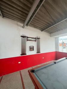 a pool table in a room with a red wall at Hotel Familiar La Esmeralda in Tocaima