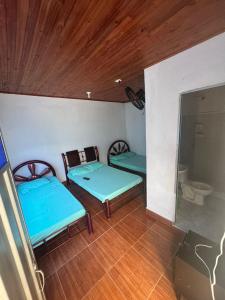 a room with two beds and two chairs in it at Hotel Familiar La Esmeralda in Tocaima