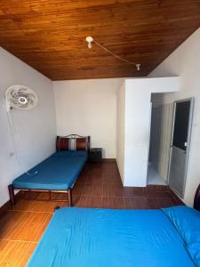 a room with a blue bed and a wooden ceiling at Hotel Familiar La Esmeralda in Tocaima