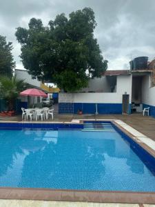 a large swimming pool with a table and chairs at Hotel Familiar La Esmeralda in Tocaima