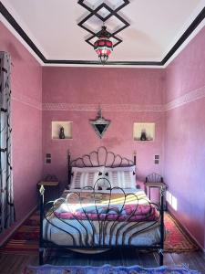 Charmante appartement privée في الصويرة: غرفة نوم بسرير في جدار وردي