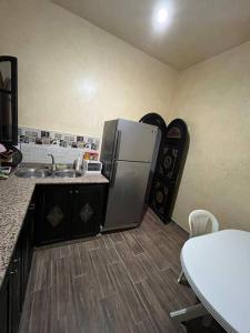 Charmante appartement privée في الصويرة: مطبخ مع ثلاجة ومغسلة وطاولة