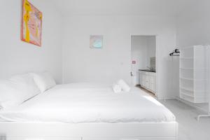 ein weißes Schlafzimmer mit einem großen weißen Bett. in der Unterkunft Sao Victor Suites in Porto